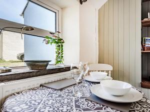 a dining room with a table with plates and glasses at Studio Cottage in Treffynnon 