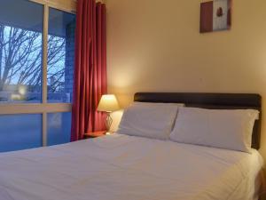 a bedroom with a white bed and a window at Atlantic Lodge in Saint Columb Major