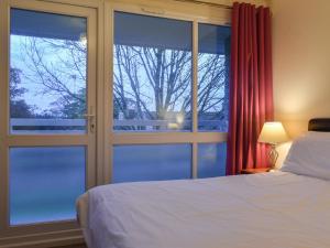 a bedroom with a bed and a large window at Atlantic Lodge in Saint Columb Major