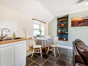 a kitchen and dining room with a table and chairs at Studio Cottage in Treffynnon 