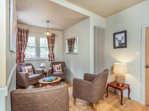 a living room with two chairs and a table at East Lodge in Contin