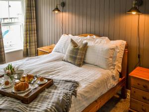 a bed with a tray of food on it at Allotment Cottage in Rothbury