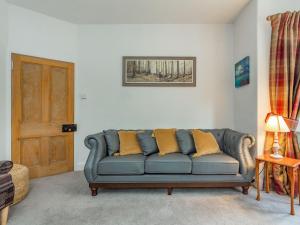 a living room with a blue couch with yellow pillows at East Lodge in Contin