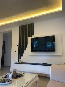 a living room with a flat screen tv on the wall at Villa Aurea in Bihać