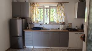 a kitchen with a refrigerator and a sink and a window at Domek w pięknej okolicy in Chmielów