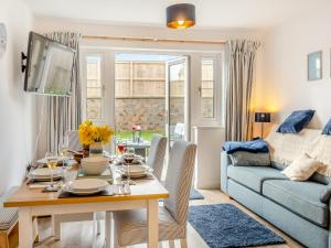 a living room with a table and a couch at Blue Skies in Carew