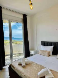 a bedroom with a bed with a view of the ocean at Electra The Seaside Apartments in Sarandë