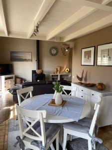 ein Esszimmer mit einem weißen Tisch und Stühlen in der Unterkunft Ferienhaus für 4 Personen ca 100 m in Adinkerke, Flandern Plopsaland und Umgebung in Adinkerke