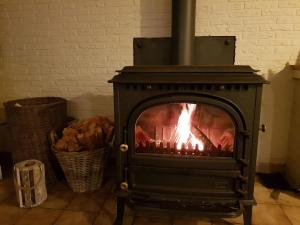 einen Herd mit Kamin in einem Zimmer in der Unterkunft Ferienhaus für 4 Personen ca 100 m in Adinkerke, Flandern Plopsaland und Umgebung in Adinkerke