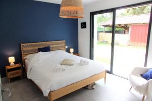 a bedroom with a bed with two towels on it at Spacious house with garden in Soustons