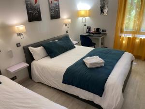 a bedroom with a large bed and a desk at Hôtel Beausoleil in Montélimar