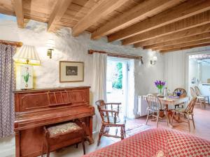 a living room with a piano and a table at Hallowarren Barn in Saint Anthony