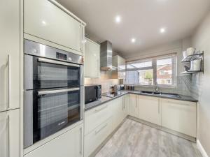 eine Küche mit weißen Schränken und Geräten aus Edelstahl in der Unterkunft House In The Hills in Church Stretton