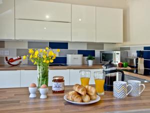 Una cocina con una mesa con un plato de croissants y bebidas. en Blackbird Cottage, en Kings Nympton