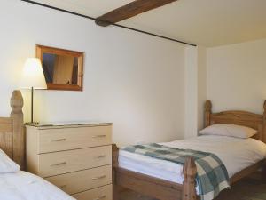 1 Schlafzimmer mit 2 Betten, einer Kommode und einem Spiegel in der Unterkunft Stable Cottage in Oswestry