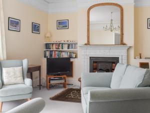 a living room with a fireplace and a mirror at Bessborough in Saint Mawes