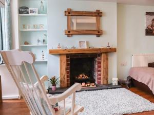sala de estar con chimenea y mecedora en Chapel Street Cottage, en Amlwch