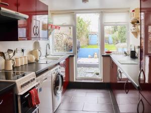una cocina con fregadero y lavadora en Chapel Street Cottage, en Amlwch