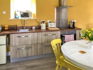 eine Küche mit einem Tisch, einer Spüle und einer Theke in der Unterkunft The Old Bakehouse in Perranporth