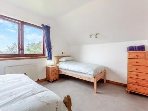 a bedroom with two beds and a dresser and a window at Drummond House Uk42979 in Brackley