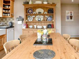 a kitchen with a wooden table with chairs at Black Bank House in Studdon