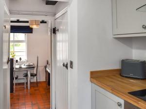 a kitchen with white cabinets and a counter top at Quay Cottage in Bewdley