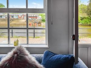 a dog sitting on a couch looking out of a window at Quay Cottage in Bewdley