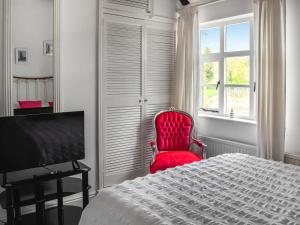 a bedroom with a red chair and a bed and a window at Quay Cottage in Bewdley +4 photos
