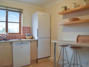 a kitchen with a refrigerator and two bar stools at Ty Celyn in Broad Haven +11 photos