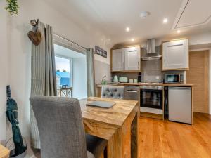 una cocina con mesa de madera y ordenador portátil. en The Granary - Uk45696, en Pickering 6 fotos más