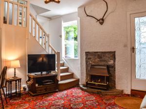 a living room with a fireplace and a tv at Kiln Cottage in Bolton le Sands