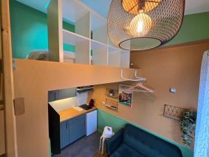 una stanza soppalcata con un divano blu e una scala di 3D- Studio tout équipé avec cuisine 10 mins de Paris a Issy-les-Moulineaux