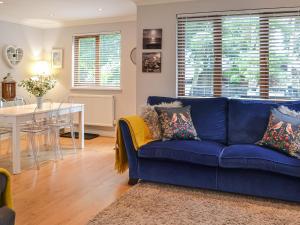 Un sofá azul en una sala de estar con una mesa. en Folly Lodge, en Sewerby