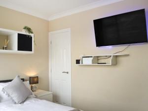 a bedroom with a bed and a flat screen tv on the wall at Oceans 44 in Sewerby