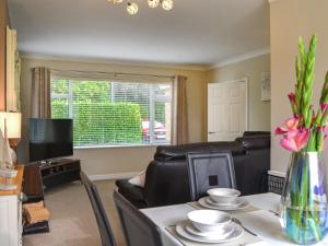 a living room with a couch and a table with flowers at Oceans 44 in Sewerby