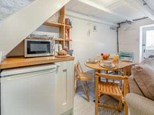 a kitchen and dining room with a microwave and a table at Fishermans Cottage in St Ives