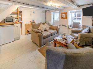 a living room with couches and a table at Fishermans Cottage in St Ives