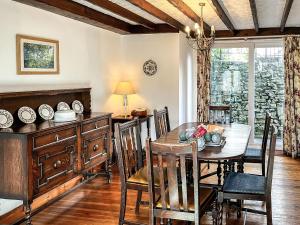 a dining room with a wooden table and chairs at Butterfield Cottage in Tideswell