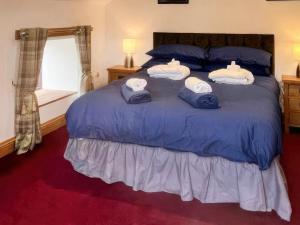 Un dormitorio con una cama azul con toallas. en Stewards Granary - Uk48306, en Berwick-Upon-Tweed
