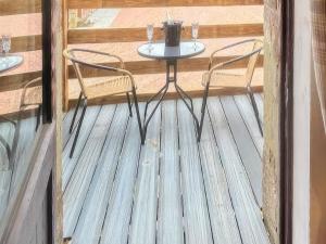 Una pequeña mesa y sillas en una terraza de madera. en Stewards Granary - Uk48306, en Berwick-Upon-Tweed 3 fotos más