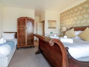 a bedroom with two beds and a wooden headboard at Heatherdene in Goathland
