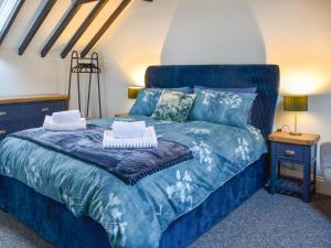 a bedroom with a blue bed with two pillows at Norfolk Headquarters in Fakenham +11 photos