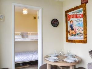 a dining room with a table and a movie poster at Yeolde Woodern Country View Seashak - Uk46596 in Bridlington +10 photos