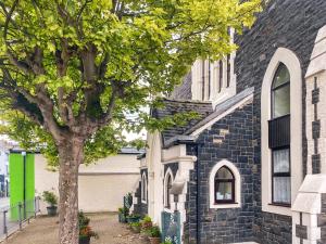 a black and white house with a tree in front of it at Chapel Court Loft Apartment in Beaumaris +2 photos