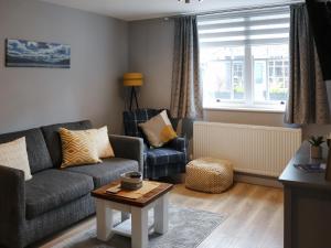 a living room with a couch and a chair at Llety Cariad in Bala