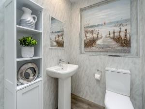 a white bathroom with a sink and a toilet at The Mulberry in Lamlash