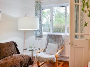 a living room with a chair and a lamp at Farmers Cottage in Withernsea
