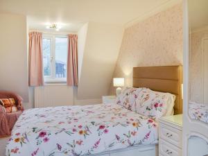 a bedroom with a bed with a floral bedspread at Farmers Cottage in Withernsea