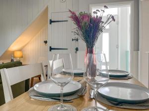 a table with plates and glasses and a vase with flowers at Rose Cottage in Cromford