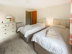 a bedroom with two beds and a dresser at The Old Sawmill One - Uk49336 in Plumpton Green